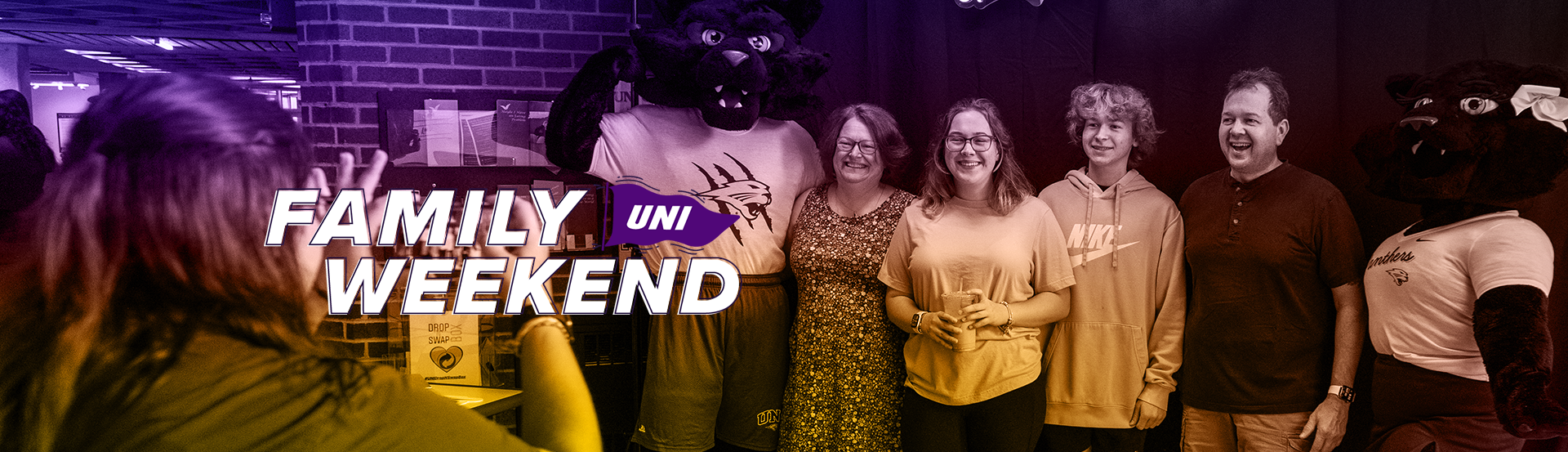 Family taking photo at Family Weekend with Family Weekend Logo in top Left corner 